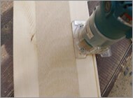 トリマーで背板のベニヤを入れる溝を掘ります
