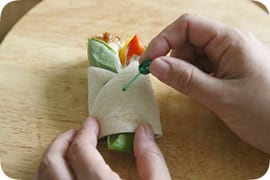 具をのせたトルティーヤを端からくるくる巻いて、ピックで止める