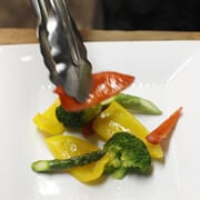 フライパンにオリーブオイルを入れ、中弱火で野菜をグリルし、皿に盛りつける