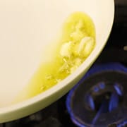 フライパンにオリーブオイルを入れ、叩き潰したニンニクを入れる