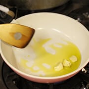 鍋にオリーブオイルを入れ、つぶしたニンニクを入れて加熱する